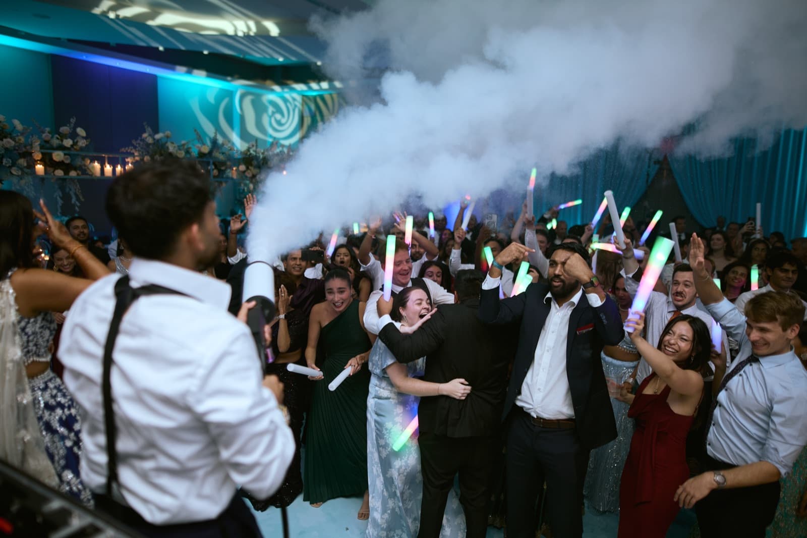 CO2 cannon firing over a dance floor of guests waving multicoloured LED foam sticks